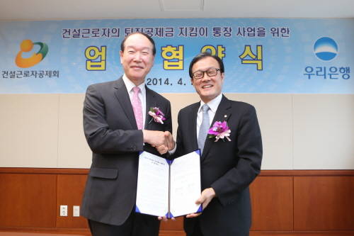 이순우 우리은행장(사진 오른쪽)이 이진규 건설근로자공제회 이사장과 퇴직공제금 지킴이 통장 사업에 대한 업무협약 체결 후 기념촬영을 하고 있다.(사진제공=우리은행)