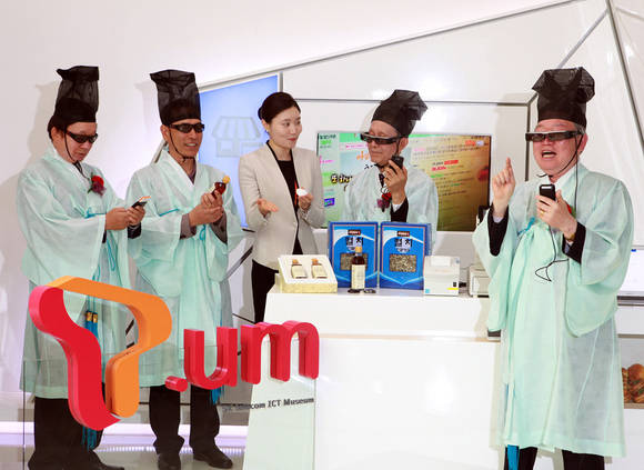 7일 오전 SK텔레콤 T.um(티움)에서 열린 ICT 체험 행사에 참가한 성균관 유도회 회원들이 스마트 글래스를 통해 매장 소개동영상을 감상하고 있다(사진 제공: SK텔레콤)