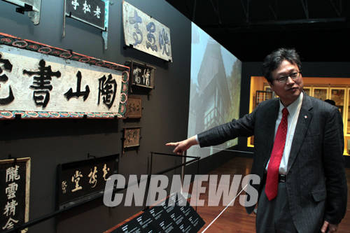 16일 서울 삼청로 국립민속박물관 기획전시실에 진행된 '목판, 지식의 숲을 거닐다'특별전에 공개된 안동 도산서원 현판을 천진기 국립민속박물관 관장이 설명하고 있다.(사진=왕진오 기자)