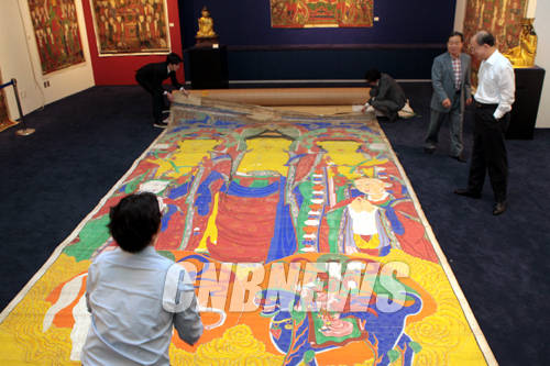 29일 서울 종로구 관훈동 (주)마이아트옥션 옥션하우스에서 공개된 서울시 중요무형문화재 제123호 '아미타삼존괘불도'를 옥션 관계자들이 살펴보고 있다. 이 추정가 5억에서 7억에 경매에 부쳐진 이 불화는 도난된 것으로 알려져 관계당국이 수사에 나선 작품이다.(사진=왕진오 기자)