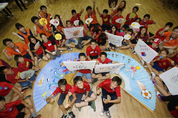16일 오후 서울 은평구 응암동에 위치한 꿈나무마을 어린이들이 직접 제작한 대형부채와 손수건을 펼치며 첫 경기를 앞둔 태극전사들을 응원하고 있다(사진 제공: 한화그룹)