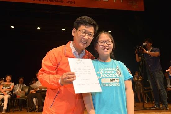 민선6기 최성 고양시장에게 자신이 직접 만든 임명장을 수여한 서정초 6학년 박유현 어린이와 최성 시장이 기념촬영하고 있다.