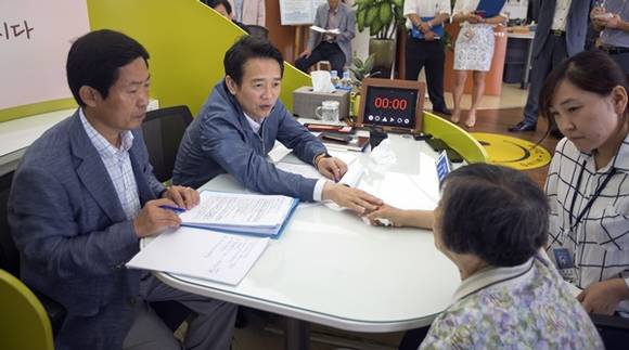 22일 오전 억울함을 남 지사에게 호소하던 한 할머니가 눈물을 흘리자 황급히 티슈를 건네며 할머니를 위로하고 있다.(사진=경기도 제공)