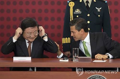 이형근 기아자동차 부회장(왼쪽)과 엔리케 페냐 니에토 멕시코 대통령이 27일(현지시간) 멕시코 멕시코시티에서 열린 기아차 현지공장 건설을 위한 투자계약 조인식 도중 대화를 나누고 있다(사진: 연합뉴스)