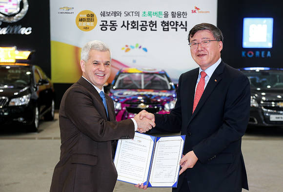 SK텔레콤 박인식 사업총괄(오른쪽)과 한국지엠 세르지오 호샤 사장(왼쪽)이 협약을 체결하고 손을 맞잡고 있다(사진 제공: SK텔레콤)