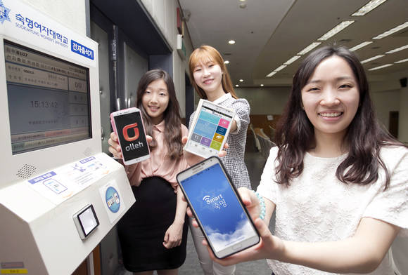 숙명여자대학교 학생들이 교내 캠퍼스에서 ‘스마트 숙명’ 앱을 보여주고 있다(사진 제공: KT)
