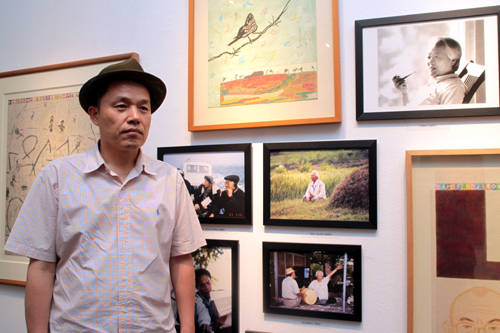 롯데갤러리 본점에 전시된 이청준의 사진과 함께한 김선두 작가.(사진=왕진오 기자)