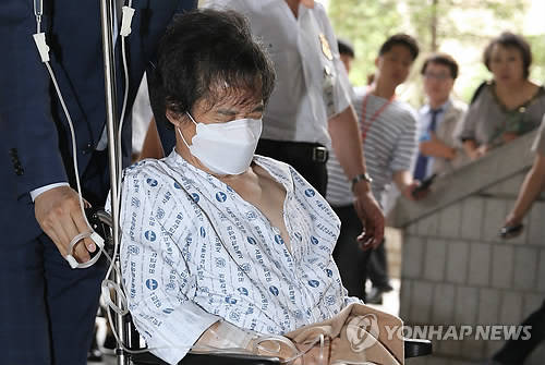 12일 오후 서울 서초동 서울고등법원에서 열리는 항소심 선고 공판에 출석하기 위해 휠체어에 탄 채 이동중인 이재현 CJ 회장(사진: 연합뉴스)