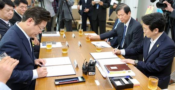 23일 오후 경기도지사 집무실에서 남경필 경기도지사와 이재명 성남시장이 판교테크노밸리 트램 건설 경기도-성남시 업무협약서에 서명을 하고 있다.(사진=경기도 제공)