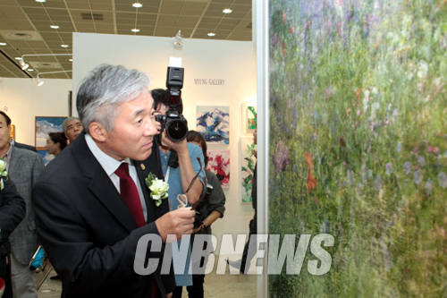 24일 오후 서울 삼성동 코엑스에서 2014 한국국제아트페어 VIP 오프닝 행사가 열렸다. 이날 자리를 함께한 김종덕 문화체육관광부 장관이 박여숙화랑에 전시된 작품을 자세히 보기 위해 안경을 벗고 관람하고 있다.(사진=왕진오 기자)