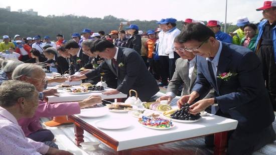 유영록 시장, 홍철호 국회의원 등이 노인들께 음식을 대접하고 있다.