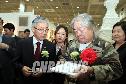 2014 KIAF 개막 당일 현장을 찾은 조지 웡 파크뷰 그린 그룹 회장이 김종덕 문체부 장관에게 자료를 건네고 있다.(사진=왕진오 기자)