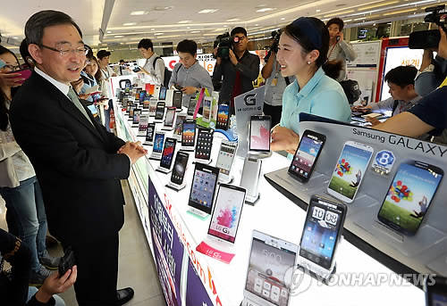 최성준 방송통신위원장이 단통법 시행 첫날인 1일 오후 서울 용산구 아이파크몰의 휴대전화 판매점을 찾아 관계자와 이야기를 나누고 있다(사진: 연합뉴스)