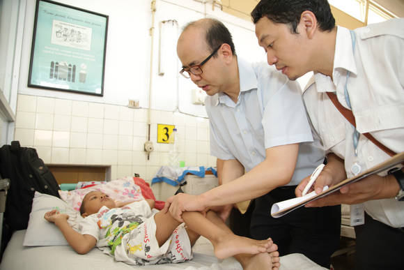 3일 인도네시아의 수토모 주립병원에서 분당서울대병원 정형외과 박문석 교수(사진 가운데)와 현지 의료진이 수술에 앞서 환아를 검사하고 있다(사진 제공: KT&G복지재단)
