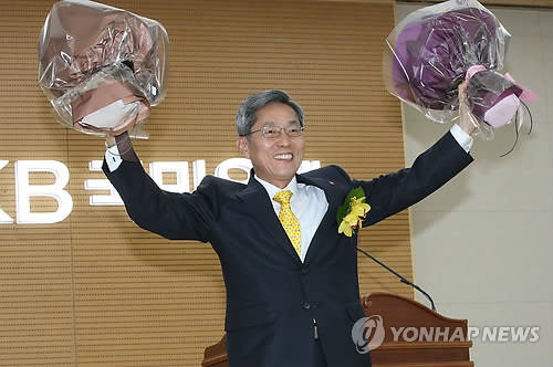 윤종규 신임 KB금융지주 회장이 21일 오후 서울 여의도 국민은행 본점에서 열린 취임식에서 꽃다발을 들고 활짝 웃고 있다(사진: 연합뉴스)