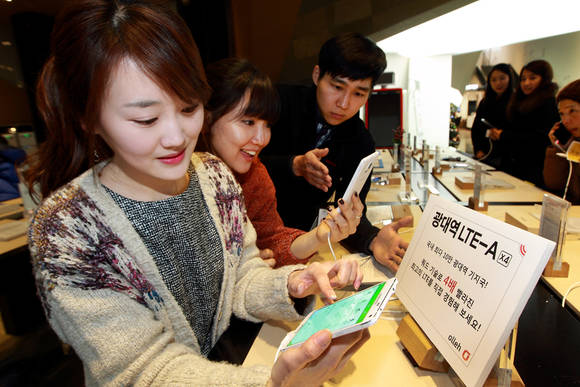서울 광화문에 위치한 올레스퀘어에 방문한 고객들이 ‘광대역 LTE-A X4’가 적용된 삼성 갤럭시 노트4 단말을 체험하고 있다(사진 제공: KT)