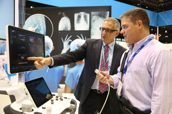 ‘2014 북미영상의학회’ 삼성전자 부스에서 최신 영상의학과용 초음파 영상진단기 ‘RS80A’ 설명을 듣고 있는 방문객(사진 제공: 삼성전자)