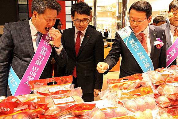 정건희 신세계 센텀시티점장(가운데)과 박노욱 봉화군수(왼쪽)가 봉화사과를 직접 시식하고 있다.