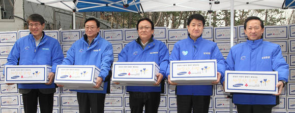 10일 서울 용산구에 위치한 서울역 쪽방지역에서 삼성 사장단이 노인들에게 전달할 생필품을 나르고 있다. 왼쪽부터 박동건 삼성디스플레이 사장, 박대영 삼성중공업 사장, 박근희 삼성사회봉사단 부회장, 김창수 삼성생명 사장, 윤용암 삼성증권 사장(사진 제공: 삼성사회봉사단)