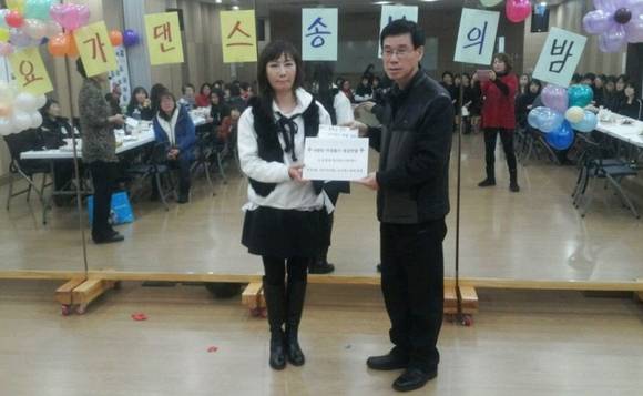 우홍환 간석3동 동장에게 주민자치프로그램 수강생들이 바자회 수익금을 기탁 하는 모습.(사진=인천 남동구)