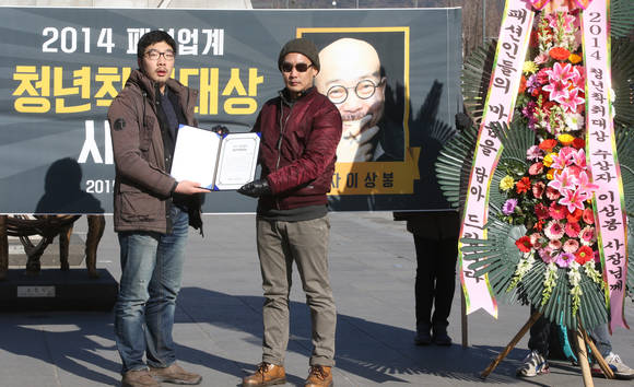 청년유니온과 패션노조 회원들이 7일 오전 서울 광화문광장에서 기자회견을 열고 패션업계에 종사하는 청년들의 열악한 근로환경을 설명한 뒤, '2014 청년착취대상'을 시상하는 퍼포먼스를 하고 있다. 패션노조는 공개댓글 투표를 통해 이상봉 디자이너를 수상자로 선정했다(사진: 연합뉴스)