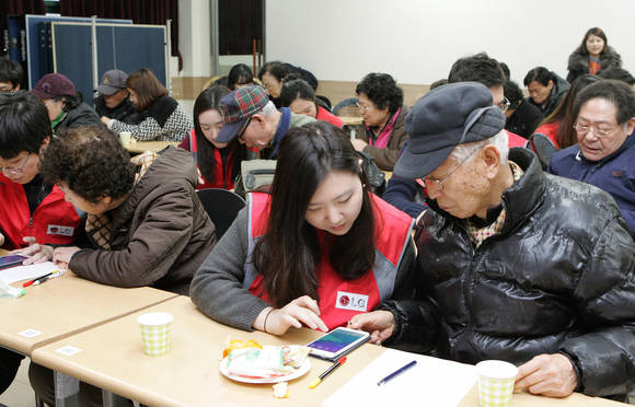 용산구 한남동의 시립용산노인종합복지관에서 1:1로 실버 스마트폰 교육을 진행하는 LG유플러스 신입사원(사진 제공: LG유플러스)