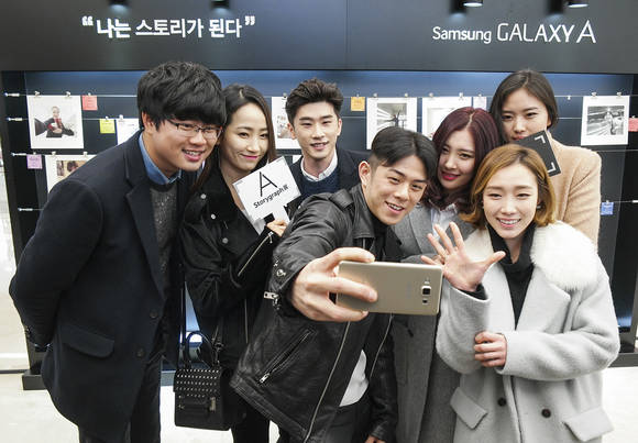 ‘갤럭시 A 스토리그래프전’에 참여한 여행작가 권준오, 원더걸스 예은, SNS 시인 최대호, 랩퍼 빈지노, 가수 선미, 스포츠 클라이밍 김자인 선수, 영화 감독 박가희(왼쪽부터)가 함께 '갤럭시 A'로 셀피를 촬영하고 있다(사진 제공: 삼성전자)