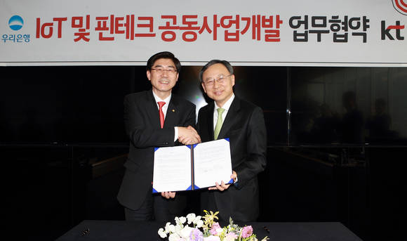 KT 황창규 회장(우측)과 우리은행 이광구 은행장이 9일 오후 KT 광화문빌딩 EAST에서 ‘사물인터넷 및 핀테크 공동 사업을 위한 업무협약’을 체결하고 있다(사진 제공: KT)