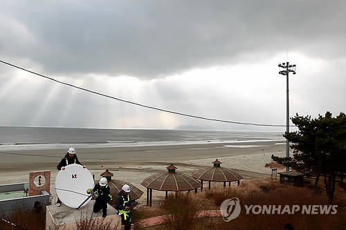 지난해 12월 17일 KT 관계자들이 백령도 사곶해수욕장 인근 주민대피소에 위성 LTE 장비를 설치하고 있다(사진: 연합뉴스)