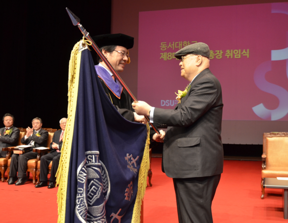 장성만 동서대 설립자(오른쪽)가 장제국 총장에게 교기를 전달하고 있다.
