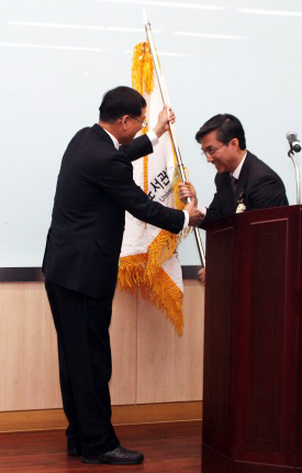 김현수(오른쪽) 동아대학교 도서관장이 최근 단국대학교에서 열린 ‘한국사립대학교 도서관협의회 2015년 정기총회’에서 이성규 단국대 도서관장으로부터 제42대 회장교기를 받고 있다. (사진제공=동아대)