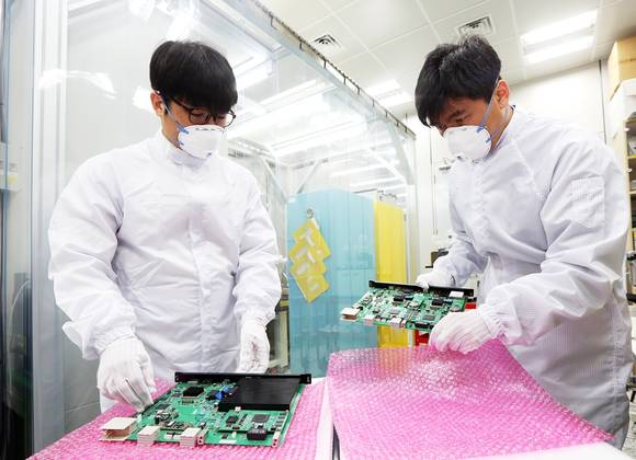 SK텔레콤 직원들이 이번 MWC에서 선보일 ‘양자 암호통신 기기’ 취급에 만전을 기하고 있다(사진 제공: SK텔레콤)