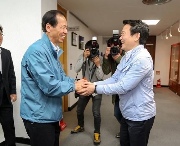 지난 11일 오전 경기도청 도지사 집무실 앞 복도에서 남경필 경기도지사와 최문순 강원도지사가 악수를 하며 인사를 나누고 있다.(사진=경기도 제공)