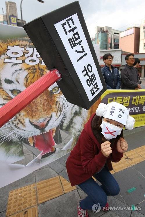 지난해 10월 22일 오후 서울 서대문구 유플렉스 앞에서 열린 단말기 유통법 대폭 보안 및 단말기 가격 거품 제거 촉구 공동기자회견에서 참가자가 법 개정 필요성을 지적하는 퍼포먼스를 하고 있다.(사진: 연합뉴스)