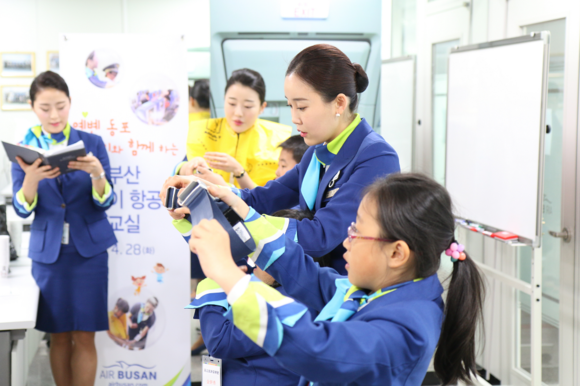 28일 연변 동포 어린이들을 대상으로 열린 ‘에어부산 어린이 항공사 체험교실’에서 캐빈승무원이 어린이들에게 좌석 안전벨트 사용법을 가르쳐 주고 있다. (사진제공=에어부산)