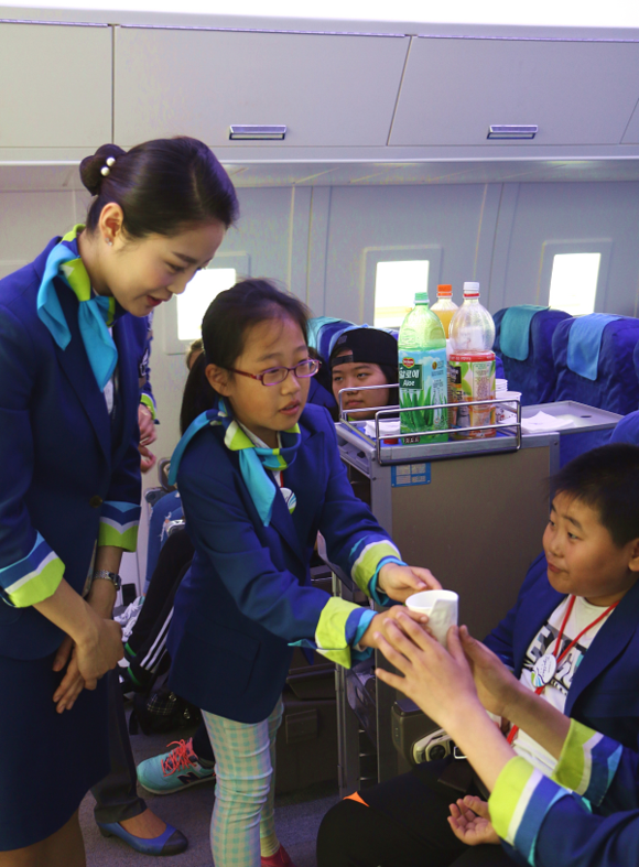 28일 연변 동포 어린이들을 대상으로 열린 ‘에어부산 어린이 항공사 체험교실’에서 참가 어린이가 기내서비스 체험을 하고 있다.
