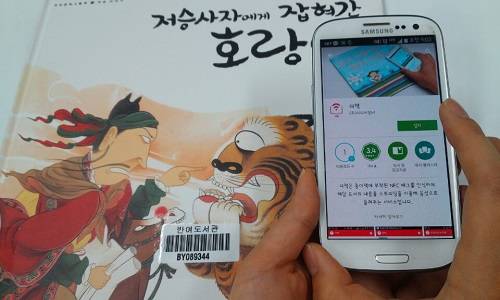 (사진제공=해운대구) 책에 스마트폰을 갖다대면 전문성우가 이야기를 들려주는 더 책을 실시했다