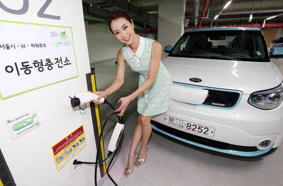 KT 광화문사옥 주차장에서 한 모델이 근거리 무선통신장치(RFID)가 내장된 이동형 단말기를 이용해 전기차 충전을 시연하고 있다.(사진 제공: KT)