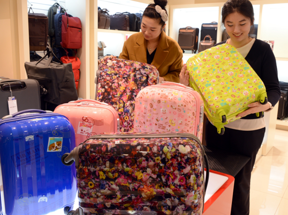 5월 연휴로 인해 여행 수요가 증가하고 있는 가운데, 롯데백화점 부산본점 2층 델시 가방매장에서 여성들이 다양한 디자인이 적용된 캐리어를 살펴보고 있다. (사진제공=롯데백화점)