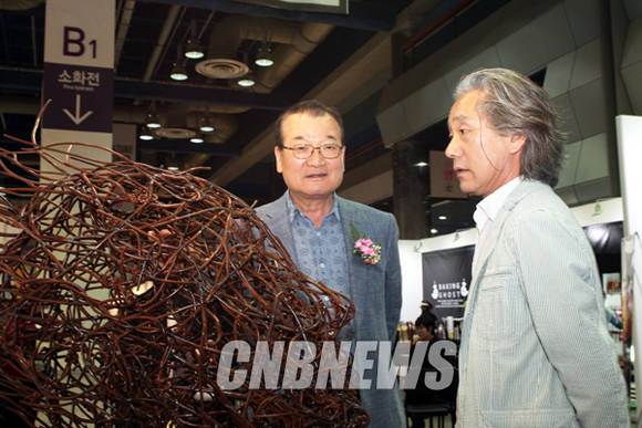 20일 오후 서울 삼성동 코엑스에서 진행된 서울오픈아트페어(SOAF) 개막식에 함께한 윤영달 크라운해태제과 회장(사진 좌측)이 전시된 작품을 보고 있다.(사진=왕진오 기자)