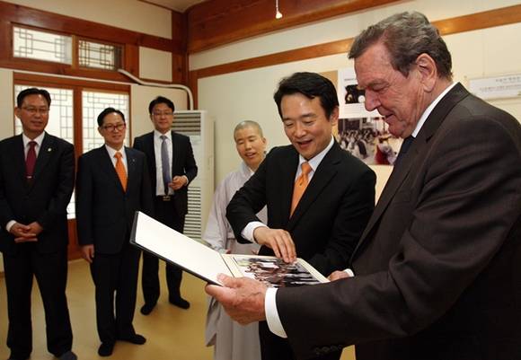 22일 오후 수원 봉녕사에서 열린 오찬 간담회를 마친 후 남경필 경기도지사가 슈뢰더 전 독일총리에서 방문 기념 사진앨범을 선물하며 설명을 하고 있다.(사진=경기도 제공)