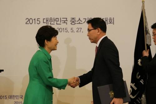 27일 청와대 영빈관에서 개최된 ‘중소기업유공자 포상 수여식’에서 박근혜 대통령이 조용병 신한은행장에게 ‘중소기업 지원우수단체 부문 대통령표창’을 수여하고 있는 모습. (사진제공=신한은행)