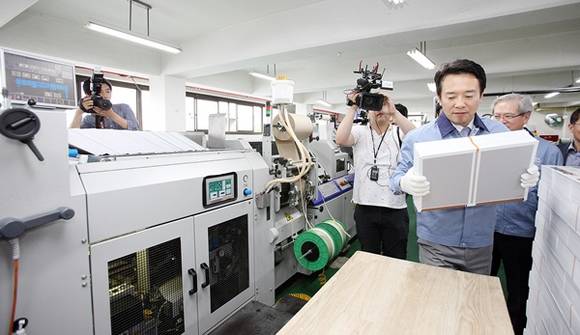 지난 18일 군포시 당정동에 위치한 (주)팩컴코리아를 방문한 남경필 경기도지사가 현장을 둘러보고 제본작업을 직접 체험하고 있는 장면(사진=경기도)