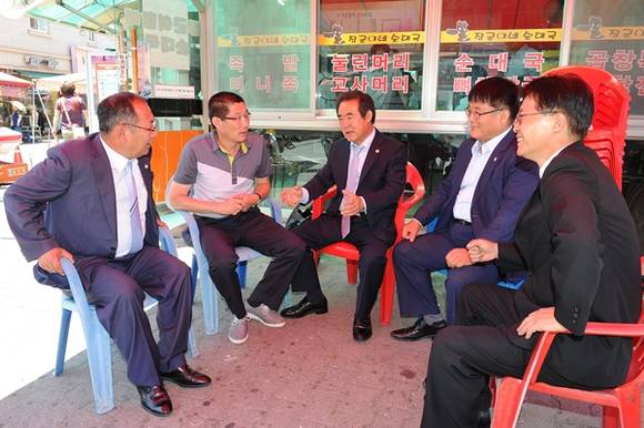 정례회를 마친 김진우 의장과 수원시의회 의원들이 재래시장을 찿아 상인들과 재래시장 활성화에 대해 논의 하고 있다.(사진=수원시의회)