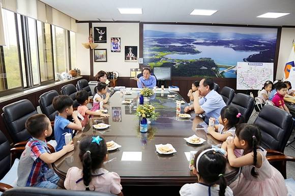 황은성 안성시장이 어린 아이들과 이야기꽃을 피우며 대화를 나누고 있다. 어린 아이들은 황 시장이 제공한 과자와 음료를 마시며 황 시장의 말에 귀를 기울이는 모습들이 사뭇 진지하다.
