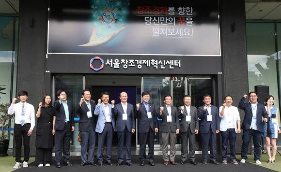 최양희 미래창조과학부 장관, 류경기 서울시 행정1부시장, 이채욱 CJ주식회사 대표이사, 박용호 센터장 등 참석자들이 17일 서울 광화문 KT빌딩의 옛 드림엔터에서 열린 서울창조경제혁신센터 출범식에서 현판을 제막한 뒤 참석자들과 기념촬영을 하고 있다(사진: 연합뉴스)