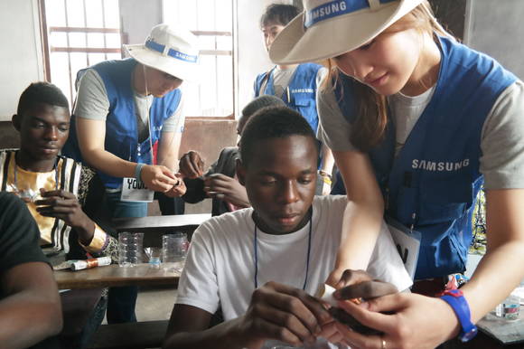 ‘삼성전자 임직원 해외봉사단’이 콩고민주공화국에서 학생들과 '태양열 충전 LED 랜턴'을 만들고 있다.(사진 제공=삼성전자)