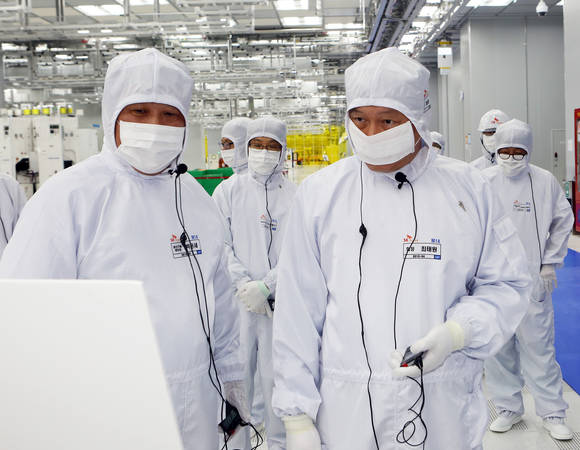 최태원 SK그룹 회장(오른쪽)이 20일 경기도 이천 SK하이닉스 사업장을 방문, 방진복을 입고 사업장을 돌아보며 박윤세 생산기술 센터장으로부터 설명을 듣고 있다. (사진=연합뉴스)