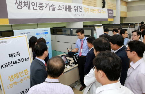 KB금융 제2차 KB핀테크 Day 행사에 참여한 생체인증 분야 한 업체가 정맥 인증을 하는 모습을 KB금융그룹 실무 직원들이 보고 있다. (사진제공=KB금융)