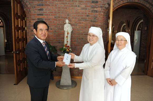 수원시의회 김진우 의장이 평화의 집을 방문해 격려금을 전달하고 있다.(사진=수원시의회)